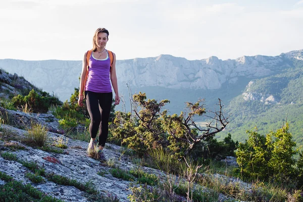 Happy young female hiking in mountains. healthy and active lifestyle. beautiful girl on nature background — Stock Photo, Image