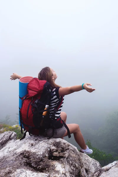 Junge kaukasische Bergwanderin, Frau wandert mit Rucksack im Nebel — Stockfoto