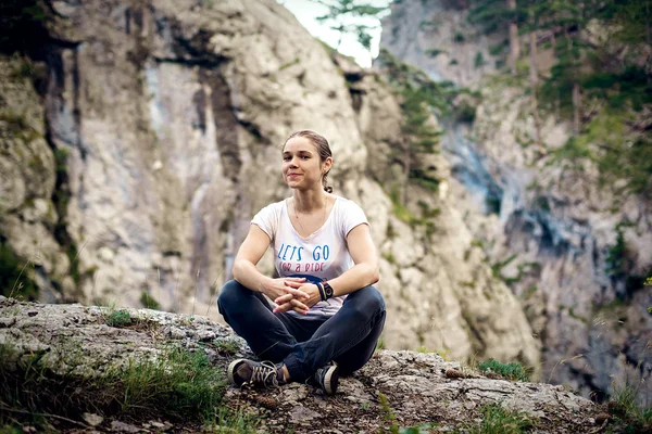 Young caucasian female sitting on a cliff in Crimea mountains — Stock Photo, Image