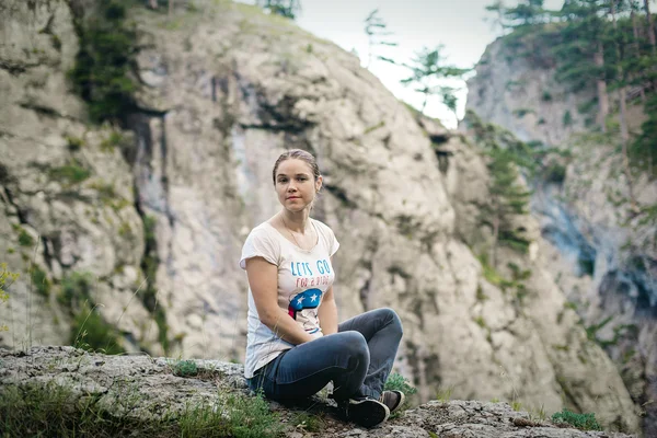 Young caucasian female sitting on a cliff in Crimea mountains — Stock Photo, Image