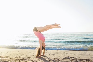 Sahilde egzersizleri yapıyor genç beyaz kadın