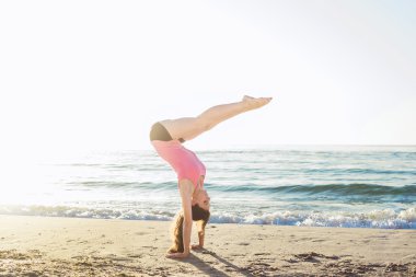 Sahilde egzersizleri yapıyor genç beyaz kadın