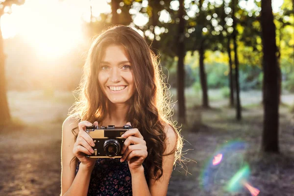 Giovane donna caucasica con fotocamera vintage nel parco — Foto Stock