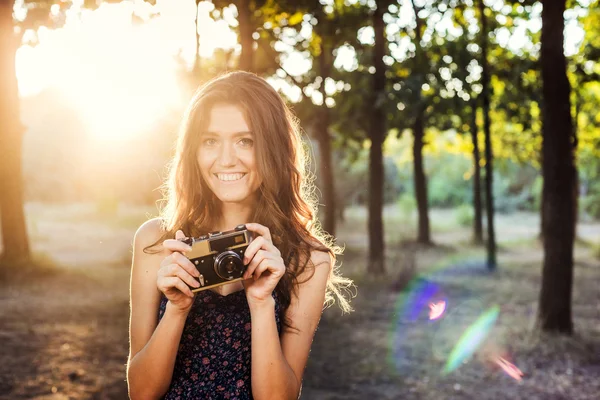 Giovane donna caucasica con fotocamera vintage nel parco — Foto Stock