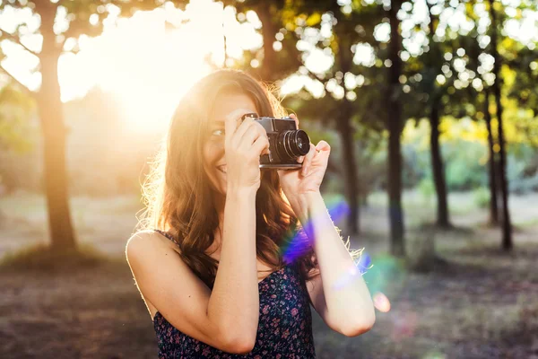 Giovane donna caucasica con fotocamera vintage nel parco — Foto Stock