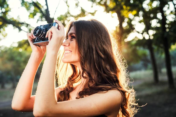 Молода біла жінка з старовинною камерою в парку — стокове фото