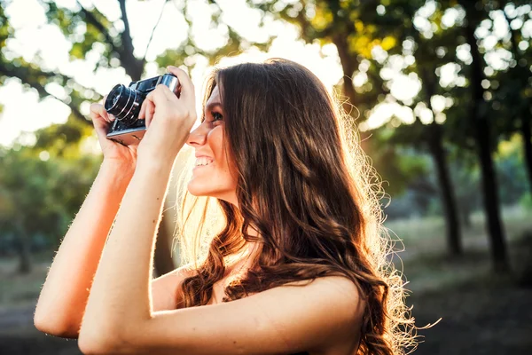 Giovane donna caucasica con fotocamera vintage nel parco — Foto Stock