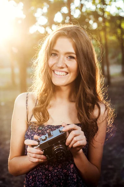 Giovane donna caucasica con fotocamera vintage nel parco — Foto Stock