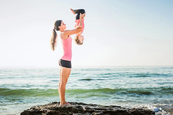 Familientraining - Mutter und Tochter machen Übungen am Strand. — Stockfoto