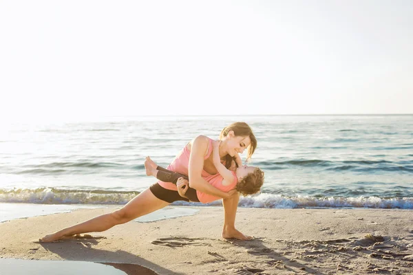 Familientraining - Mutter und Tochter machen Übungen am Strand. — Stockfoto