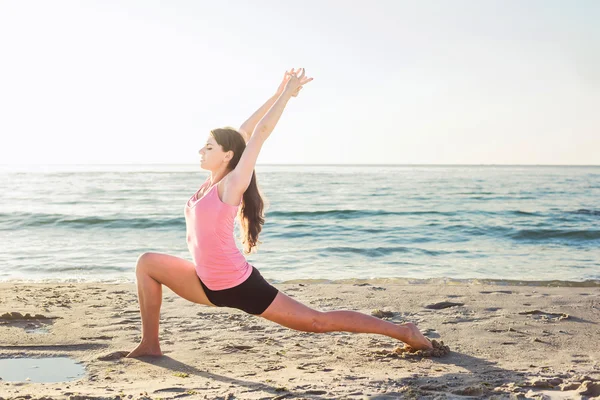 Sahilde egzersizleri yapıyor genç beyaz kadın — Stok fotoğraf