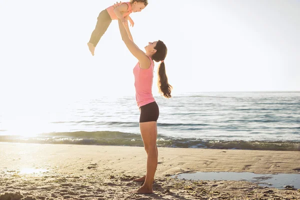 Aile egzersiz - anne ve kızı plajda egzersizleri yapıyor.