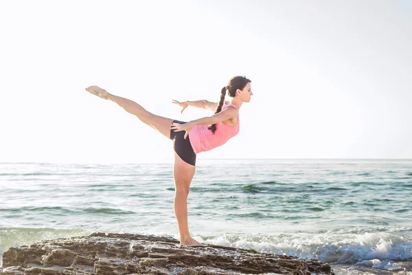 Mladý Kavkazský žena cvičení jógy u moře — Stock fotografie