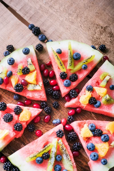 colorful tropical fruit watermelon pizza topped with kiwifruit,