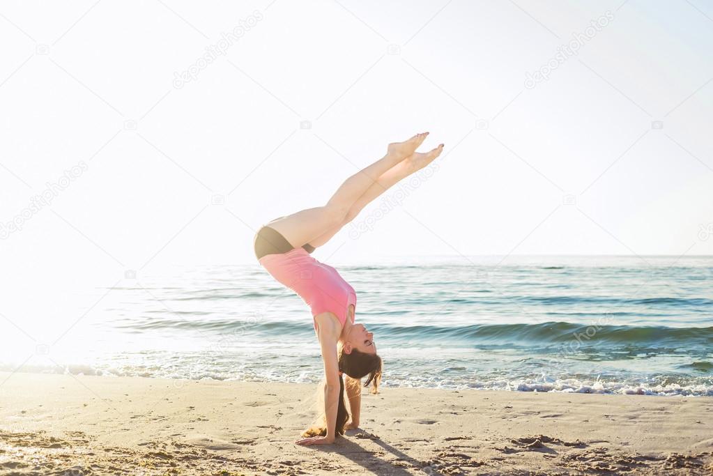 young caucasian female doing exercises on the seaside