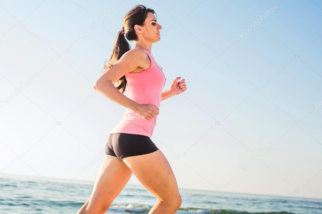 Running woman. Female runner jogging during the sunrise on beach