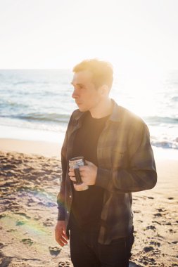 Genç beyaz erkek ile yürürken sahilde kahve içme