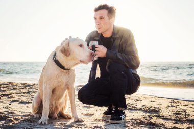 Genç beyaz erkek ile yürürken sahilde kahve içme