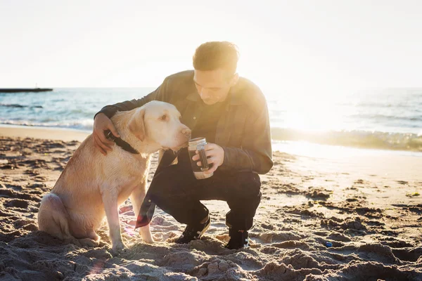 Unga kaukasiska man dricka kaffe på stranden när hon gick med — Stockfoto