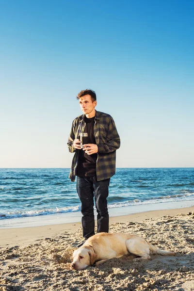 Unga kaukasiska man dricka kaffe på stranden när hon gick med — Stockfoto