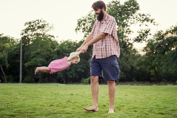 Young happy family having fun outdoors in park — Stock Photo, Image