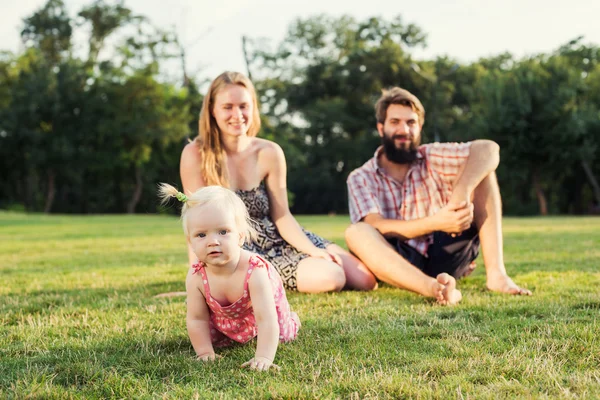 Молодая счастливая семья весело проводит время на свежем воздухе в парке — стоковое фото
