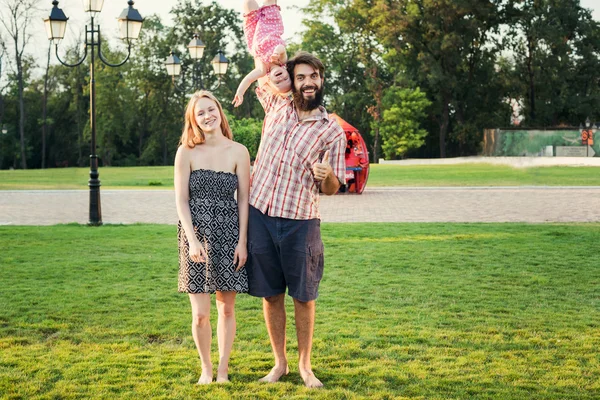 Jovem família feliz se divertindo ao ar livre no parque — Fotografia de Stock