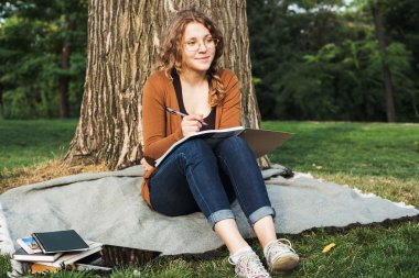 Kampüs kitapları ile genç beyaz kız öğrenci, öğrenci çalışma kampus alanının içinde