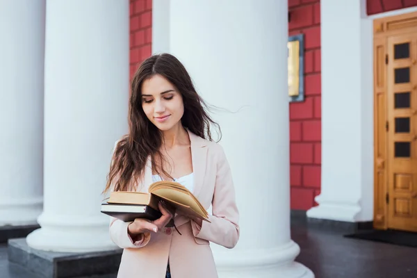 Молодая кавказская студентка с книгами и планшетами в кампусе, студентка учится в районе кампуса — стоковое фото