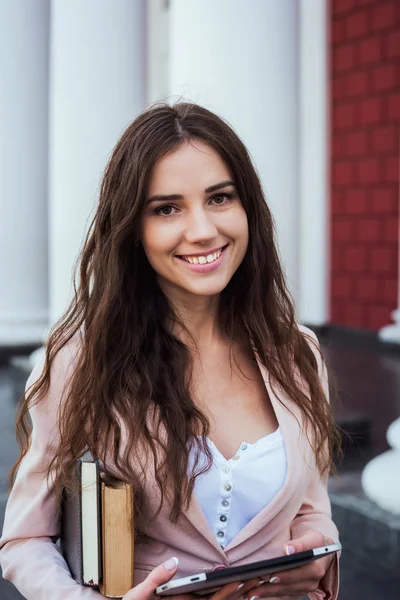 Young caucasian female student with books and tablet on campus, student study in campus area — Stock Photo, Image