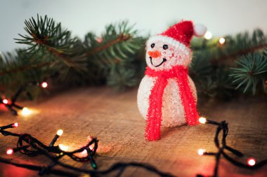 kardan adam, yılbaşı ağacı ve Noel ışıkları ahşap arka plan üzerinde. Yeni yıl ve Noel süsleri