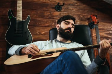 adam gitar çalıyor. Gitar duvar arka planda, aşk müzik konsepti