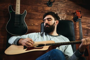 adam gitar çalıyor. Gitar duvar arka planda, aşk müzik konsepti