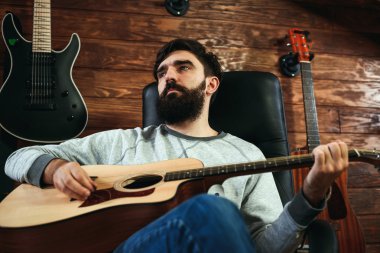adam gitar çalıyor. Gitar duvar arka planda, aşk müzik konsepti