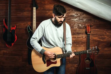 adam gitar çalıyor. Gitar duvar arka planda, aşk müzik konsepti