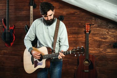 adam gitar çalıyor. Gitar duvar arka planda, aşk müzik konsepti