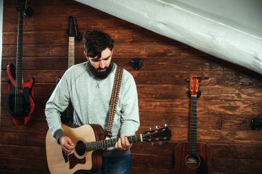 adam gitar çalıyor. Gitar duvar arka planda, aşk müzik konsepti