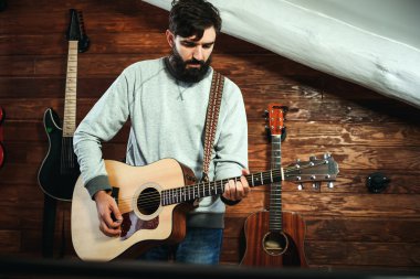adam gitar çalıyor. Gitar duvar arka planda, aşk müzik konsepti