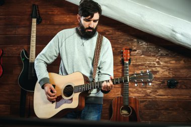 adam gitar çalıyor. Gitar duvar arka planda, aşk müzik konsepti