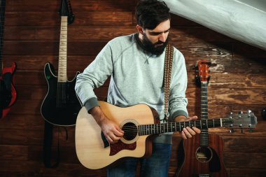 adam gitar çalıyor. Gitar duvar arka planda, aşk müzik konsepti