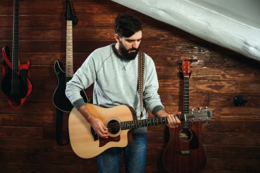 adam gitar çalıyor. Gitar duvar arka planda, aşk müzik konsepti