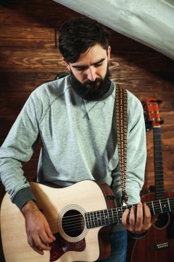 adam gitar çalıyor. Gitar duvar arka planda, aşk müzik konsepti