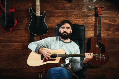 adam gitar çalıyor. Gitar duvar arka planda, aşk müzik konsepti