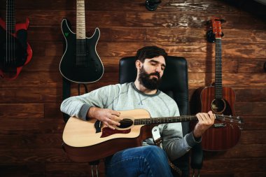 adam gitar çalıyor. Gitar duvar arka planda, aşk müzik konsepti