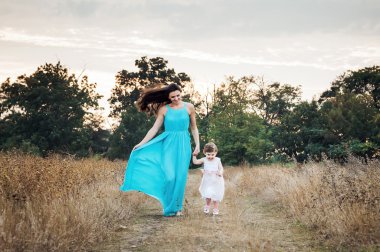 Anne ile birlikte, sonbahar sahada oynayan kız sevgi dolu aile açık havada eğlence