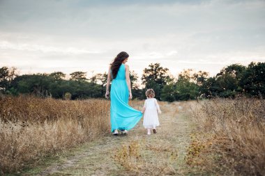 Anne ile birlikte, sonbahar sahada oynayan kız sevgi dolu aile açık havada eğlence