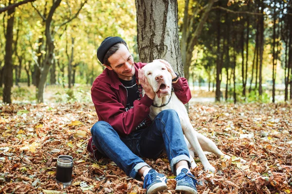 Man drinking coffee in park and playing with labrador dog — Stock Photo, Image