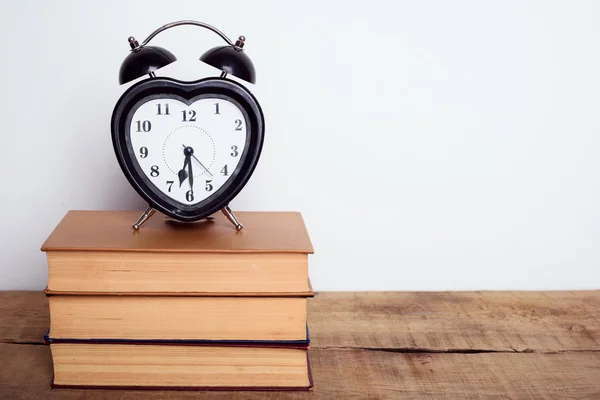 本と木製の背景の目覚まし時計。教育機器、教育コンセプト — ストック写真