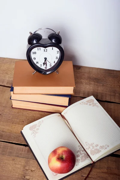 書籍、目覚まし時計、木製の背景上のメモ帳。教育機器、教育コンセプト — ストック写真