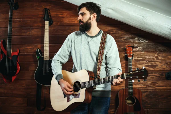 adam gitar çalıyor. Gitar duvar arka planda, aşk müzik konsepti